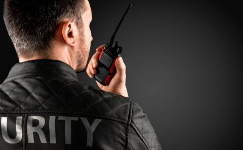 The man, security, is holding a walkie-talkie. The concept of protection, protection of information, bodyguard.